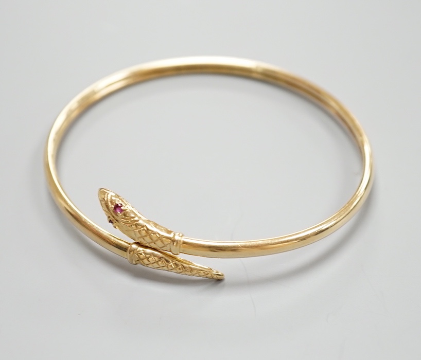 A modern 375 and gem set serpent bangle, 11.3 grams.